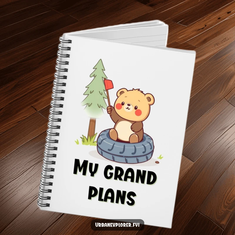 Funny round bear cub planting a miniature flag on a discarded tire, featured on the cover of a notebook.